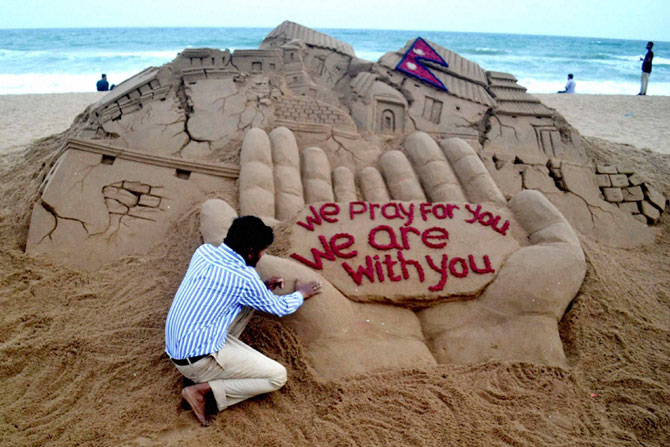 नेपाळमधील भूकंपग्रस्तांना आश्वस्त करण्यासाठी सुप्रसिद्ध वाळु शिल्पकार सुदर्शन पटनायक यांनी ओदिशातील पुरी सागरकिनाऱ्यावर साकारलेले हे शिल्प. आम्ही तुमच्यासाठी प्रार्थना करत आहोत, आम्ही तुमच्याबरोबर आहोत, असा संदेश या शिल्पातून देण्यात आला. (छाया- पीटीआय)