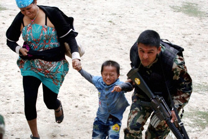 नेपाळमध्ये सध्या भूकंपग्रस्तांना सुरक्षित ठिकाणी हलविण्यात येत असून मदतकार्य वेगाने सुरू आहे. नेपाळच्या लष्करी दलाचा जवान एका लहान मुलाला आणि त्याच्या आईला सुरक्षित स्थळी नेताना. (छाया- पीटीआय)