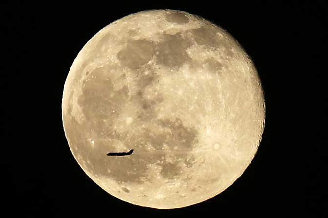 चंद्राच्या अगदी जवळून जाताना टिपलेले विमानाचे छायाचित्र. महाकाय चंद्रासमोर विमान जणू मुंगीप्रमाणे दिसत आहे. (छायाः एपी)