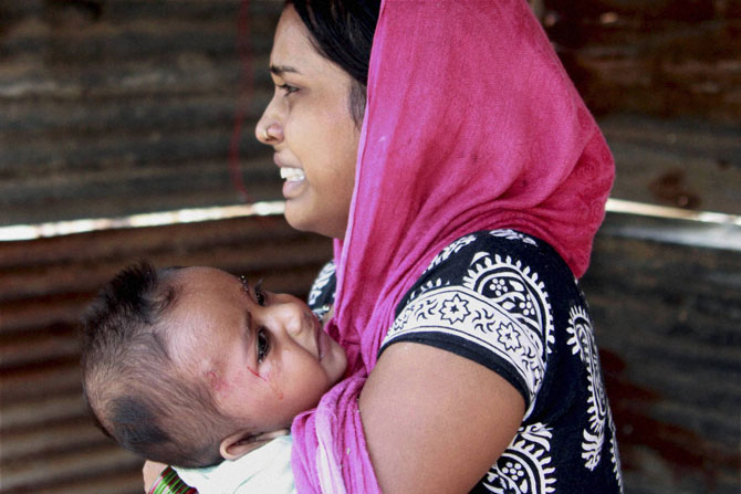 गुरगाव, हरियाणामध्ये शुक्रवारी झालेल्या दोन गटांच्या भांडणात अनेक सर्वसामान्य भरडले गेले. आपल्या जखमी लहानग्याला वाचवणाच्या धडपडीत व्याकूळ झालेली ही माता. (छाया: पीटीआय)