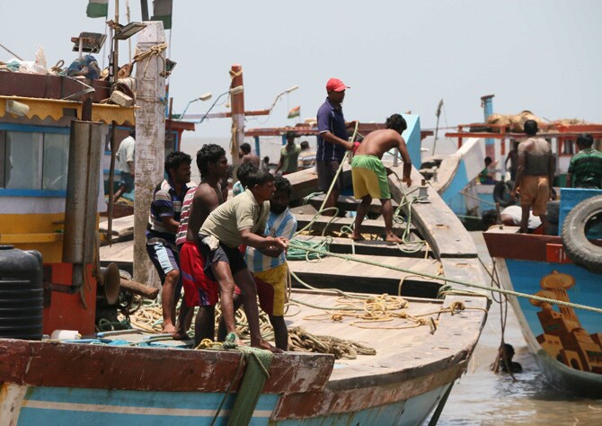 या नौका समुद्रातून बाहेर काढताना एरवी मनुष्यबळाचा वापर केला जातो. मात्र, या वेळी क्रेनच्या साह्य़ाने या नौकांना समुद्रातून बाहेर काढण्यात आले. (छाया : अमित चक्रवर्ती)