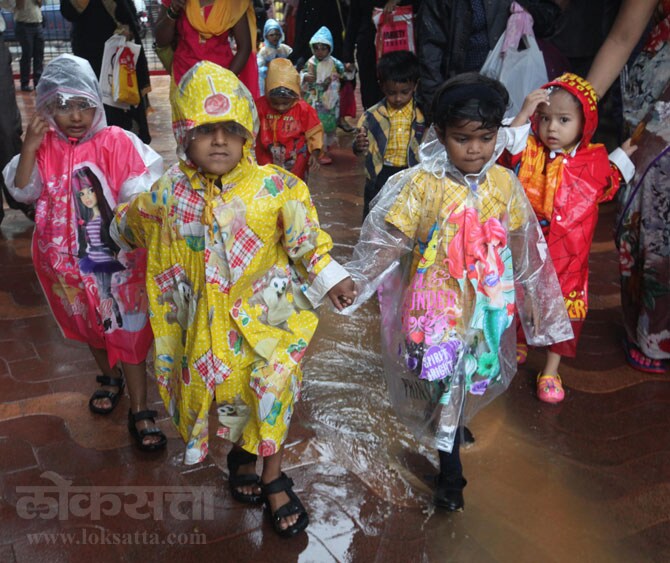 पावसाची सर कायम असूनही विद्यार्थ्यांचा शाळेचा पहिला दिवस अनुभवण्याचा उत्साह कायम होता. नवे कपडे, नवा रेनकोट घालून चिमुकली मंडळी शाळेच्या दिशेने आपल्या सवंगड्यांसह पावसाची मजा घेत जात होती. (छाया- दिपील कागडा)