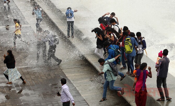 मुंबईच्या मरीनड्राईव्ह येथील समुद्रकिनाऱ्यावर बुधवारी पावसाचा आनंद लुटण्यासाठी महाविद्यालयीन तरूणांनी गर्दी केली होती. ( छाया- प्रशांत नाडकर)