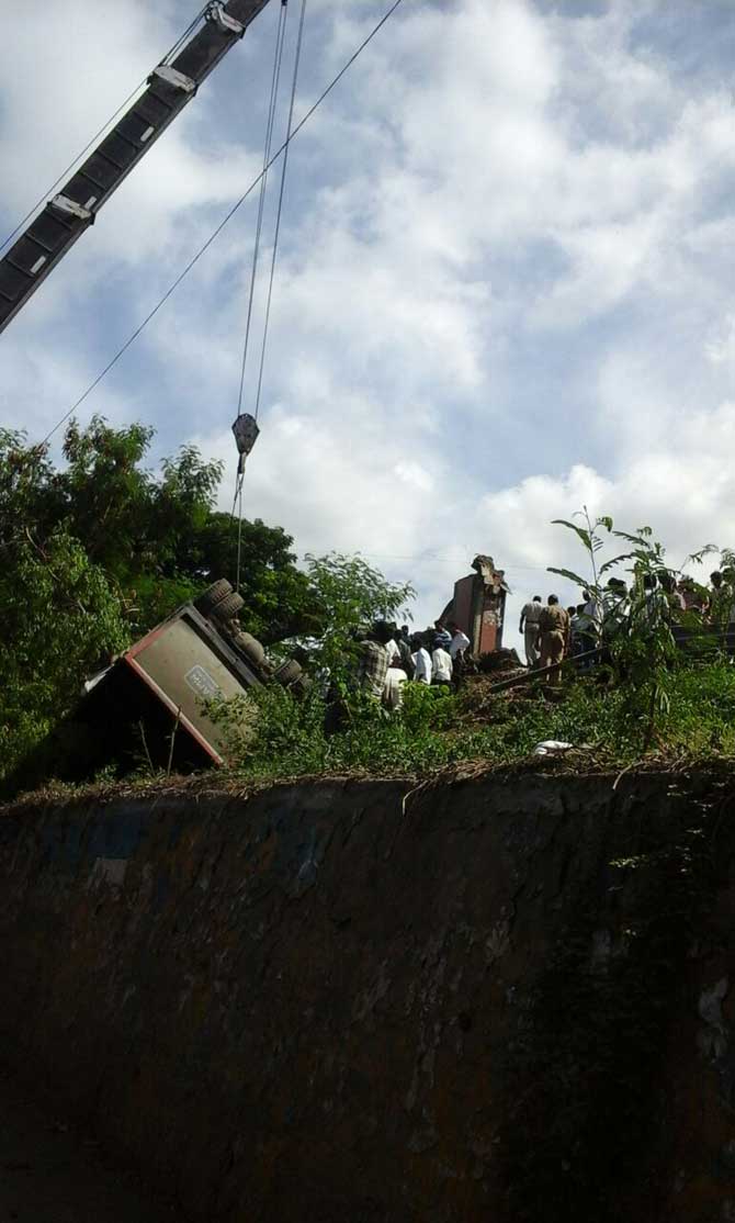 क्रेनच्या साह्याने डंपर बाजूला काढताना.