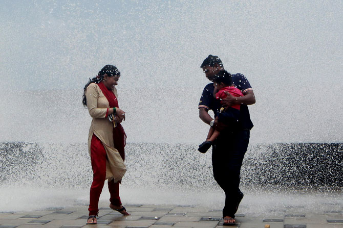 मुंबईतील वरळी सीफेसवर उंचच उंच लाटांची मजा लुटणारे कुटुंब. (छाया-केविन डिसूझा)