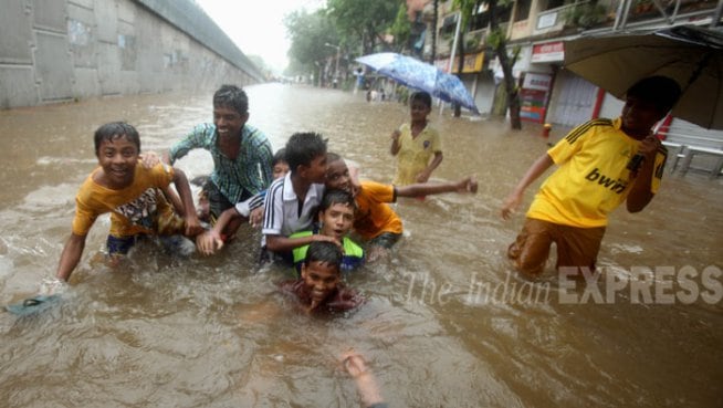मुंबईमध्ये रस्त्यावर साचलेल्या पाण्यात खेळताना ही लहान मुले.