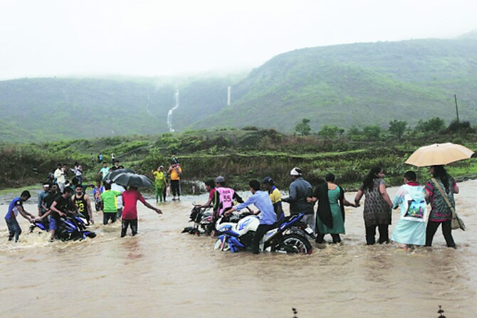 नवी मुंबईतील खारघर येथील पांडवकडा या निसर्गरम्य स्थळाला भेट देण्यासाठी आलेल्या पर्यटकांना येथील सखल भागात मुसळधार पावसामुळे पाणी साचल्याने तेथून बाहेर पडण्यासाठी तारेवरची कसरत करण्याची वेळ आली होती. (छाया - नरेंद्र वास्कर)
