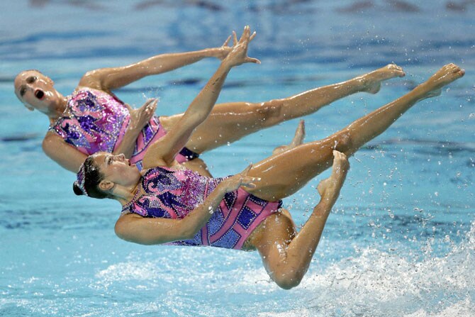 रशियातील कझान येथे आयोजित करण्यात आलेल्या जागतिक जलतरण स्पर्धेत युक्रेनच्या महिला संघातील खेळाडू हवेत झेपावल्या असताना टिपलेले छायाचित्र. (छाया- पीटीआय)