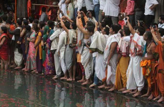 ध्वजारोहणाचा क्षण मोबाईलमधील कॅमेऱयामध्ये टिपण्यासाठी सरसावलेले भाविक. (छायाचित्र - दीपक जोशी)