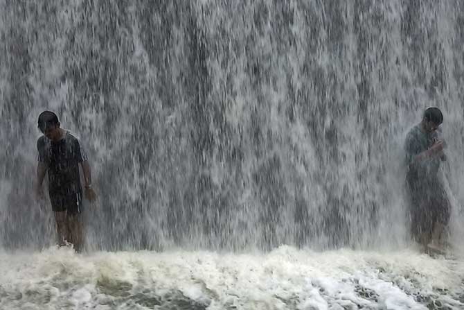 पावसाचा आनंद लुटताना तरुण. (छायाः वसंत प्रभू)