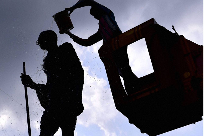 आमदाबाद येथील पालिका कर्मचारी गांधीजींच्या भव्यपुतळ्याची स्वच्छता करताना. (छाया-पीटीआय)