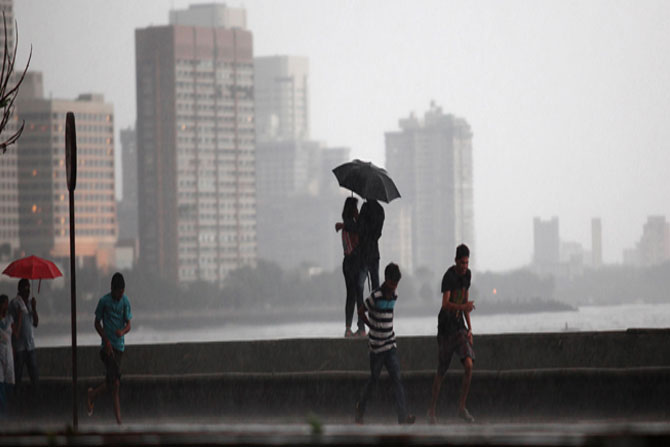 समुद्र किनारी पावसाचा आनंद घेताना प्रेमी युगूल,आणि छत्री नसल्याने त्रेधा तिरपिट उडालेले युवक. (छाया- प्रशांत नाडकर)