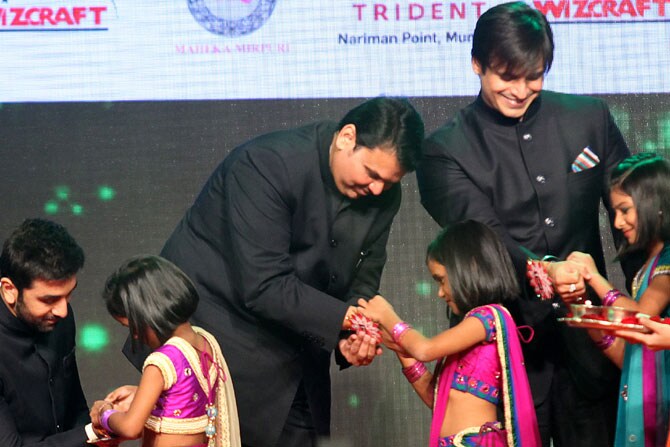 महाराष्ट्राचे मुख्यमंत्री देवेंद्र फडणवीस, रणबीर कपूर आणि विवेक ऑबरॉय यांना एका कार्यक्रमादरम्यान राखी बांधताना चिमुरड्या मुली. (छायाः प्रशांत नाडकर)