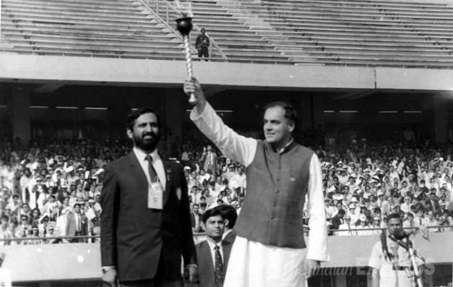 राष्ट्रकुल स्पर्धांच्या उद्घाटनावेळी मशाल उंचावताना राजीव गांधी. छायाचित्रात राजीव त्यांच्या बाजुला सुरेश कलमाडी उभे आहेत. (एक्सप्रेस अर्काईव्ह फोटो)