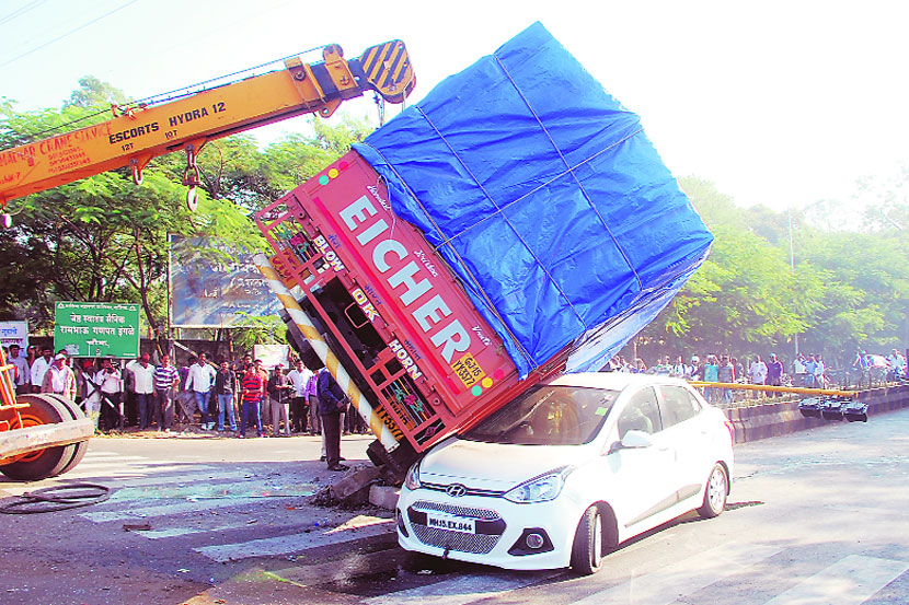 तारवाला नगर चौकात कारवर पडलेल्या अपघातग्रस्त टेम्पोला क्रेनच्या मदतीने बाजुला करावे लागले (छाया- मयूर बारगजे)