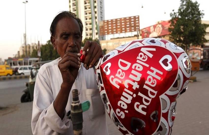 पाकिस्तान : 'हॅप्पी व्हॅलेंटाईन डे' लिहिलेल्या फुग्यांची विक्री करताना एक फुगेवाला छायाचित्रात दिसत आहे.