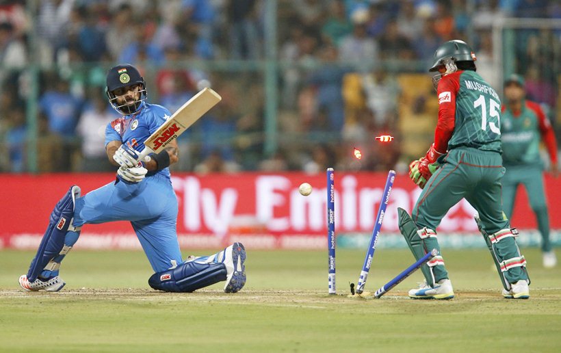 Cricket - India v Bangladesh - World Twenty20 cricket tournament - Bengaluru, India, 23/03/2016. India's Virat Kohli (L) is bowled as Bangladesh's wicketkeeper Mushfiqur Rahim looks on. REUTERS/Danish Siddiqui