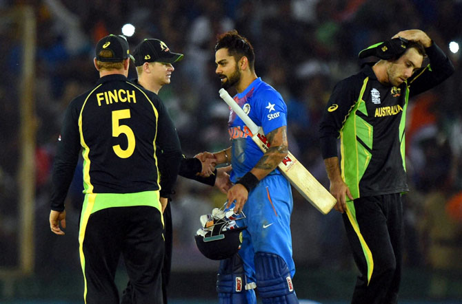 Indian batsman Virat Kohli greeted by Australian players after winning the ICC World T20 match against Australia at PCA cricket stadium in Mohali on Sunday. PTI