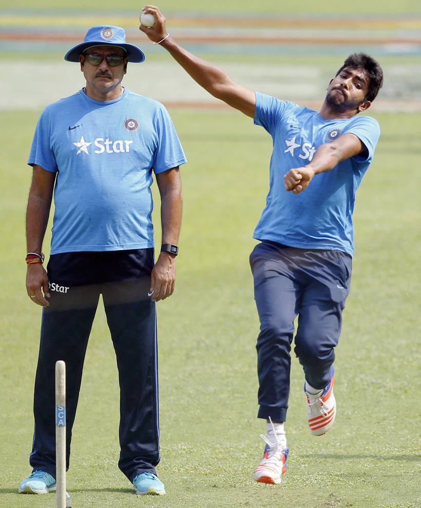 Indian cricket team director Ravi Shastri, left, watches Jasprit Bumrah bowl in the nets during a training session ahead of their ICC World Twenty20 2016 match against Bangladesh in Bangalore, India, Tuesday, March 22, 2016. (AP Photo/Aijaz Rahi)