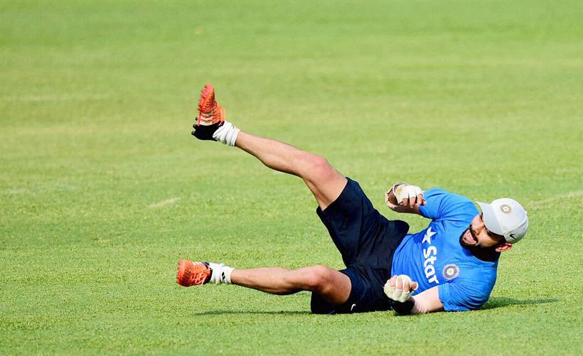 Bengaluru: Virat Kohli dives to catch the ball during a training session at Chinnaswamy Stadium in Bengaluru on Tuesday. PTI Photo by Shailendra Bhojak(PTI3_22_2016_000203A) *** Local Caption ***
