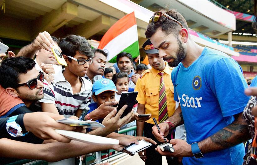Bengaluru: Cricketer Virat Kohli signs autograph for fans during a training session at Chinnaswamy Stadium in Bengaluru on Tuesday. PTI Photo by Shailendra Bhojak (PTI3_22_2016_000166B)