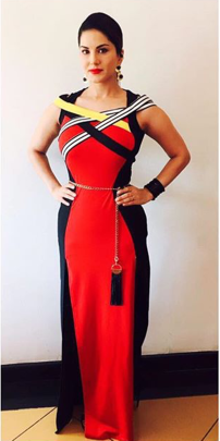 Sunny Leone wore a stunning red and black, high-slit dress for the new series of Splitsvilla, designed by Aditi Gupta. She paired the dress with black-and-gold earrings that looked amazing and a handcuff by E-Designs. In a dress that was already busy and structured around the torso, the chained belt could have been left out. As for her makeup, she opted for a bold red lip shade, and tied her hair into a low ponytail. (Source: SunnyLeone/Instagram)