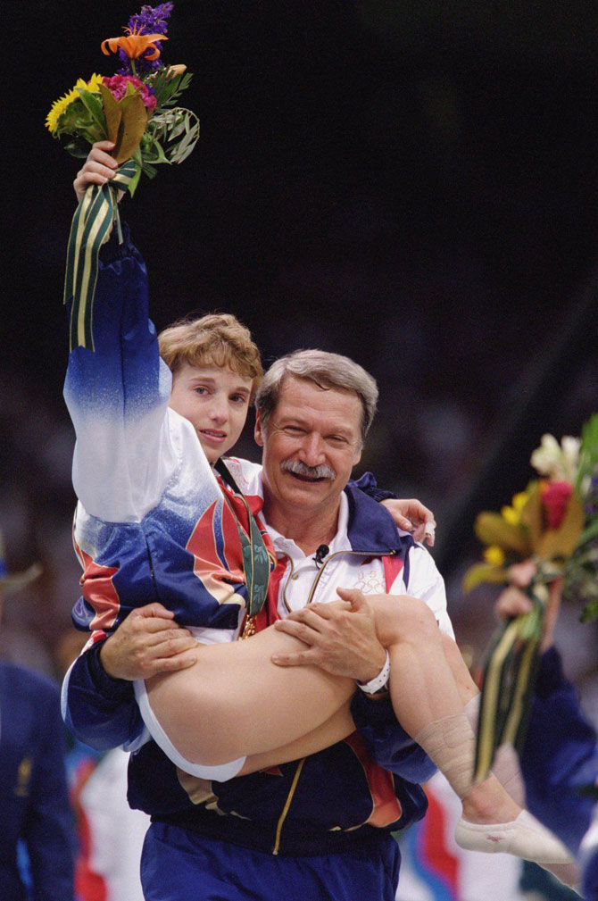 १९९६ सालच्या ऑलिम्पिक स्पर्धेत सुवर्ण पदकाला गवसणी घातलेली अमेरिकेची खेळाडू केरी स्ट्रग दुखापतग्रस्त झाल्यानंतर तिला उचलून नेताना तिचे प्रशिक्षक बेला कॅरोली. (DOUG PENSINGER / GETTY IMAGES)
