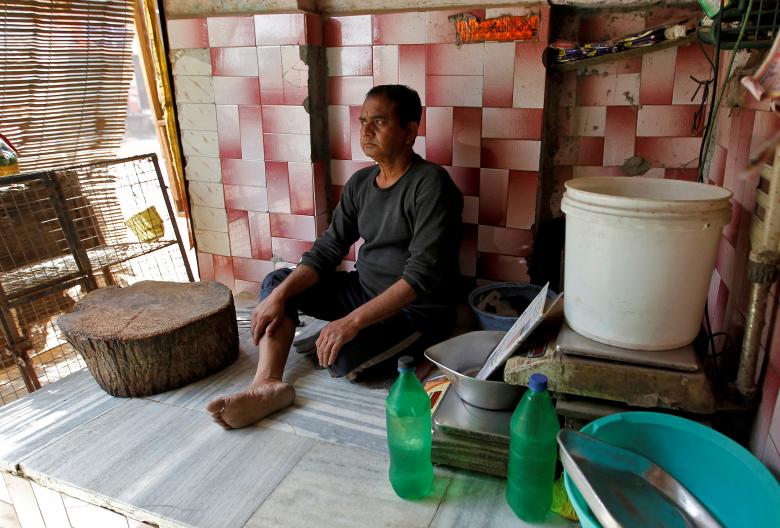 अलाहाबादमधील मटणाच्या दुकानात रिकामी बसलेली एक व्यक्ती. (REUTERS/Jitendra Prakash)