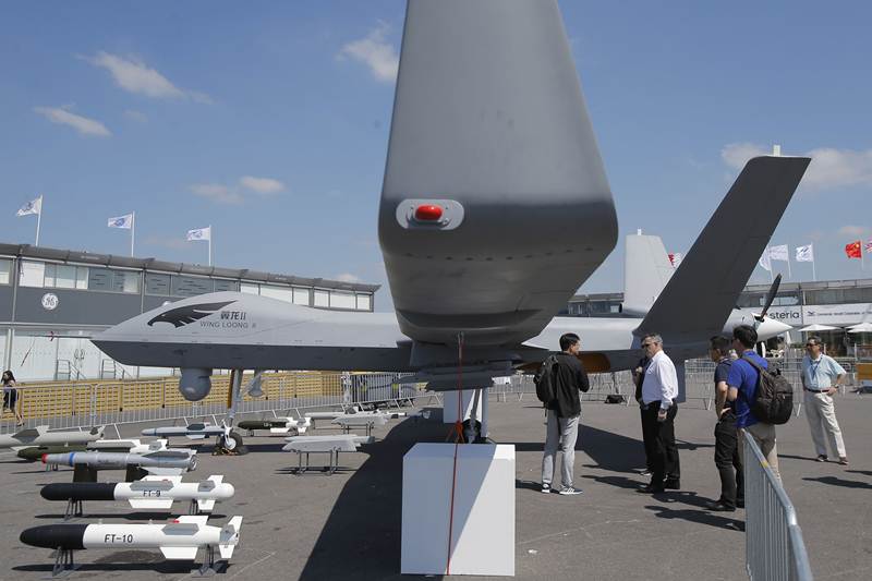 Wing Loong II Drone : हे चीनचे चालकरहित विमान आहे. प्रदर्शनाच्या ठिकाणी उपस्थित असलेले काहीजण या विमानाला न्याहाळत आहेत. (असोसिएटेड प्रेस)