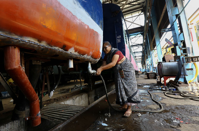 गाड्यांची साफसफाई करताना महिला कर्मचारी