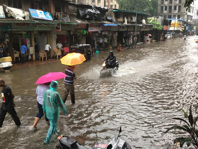 पावसाच्या साठलेल्या पाण्यातून वाट काढताना एक दुचाकीस्वार (छाया: प्रदीप दास)