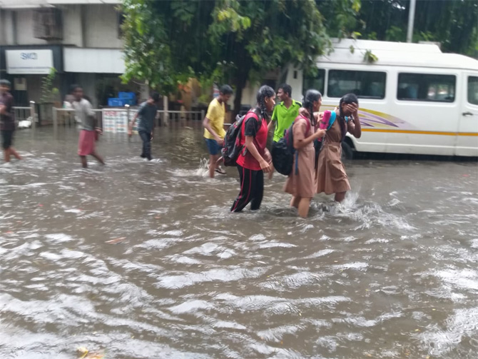 अनेक ठिकाणी पाणी साठल्याने मुलांना याच साठलेल्या पाण्यातून घरी जावे लागले. (फोटो: गणेश शिर्सेकर)