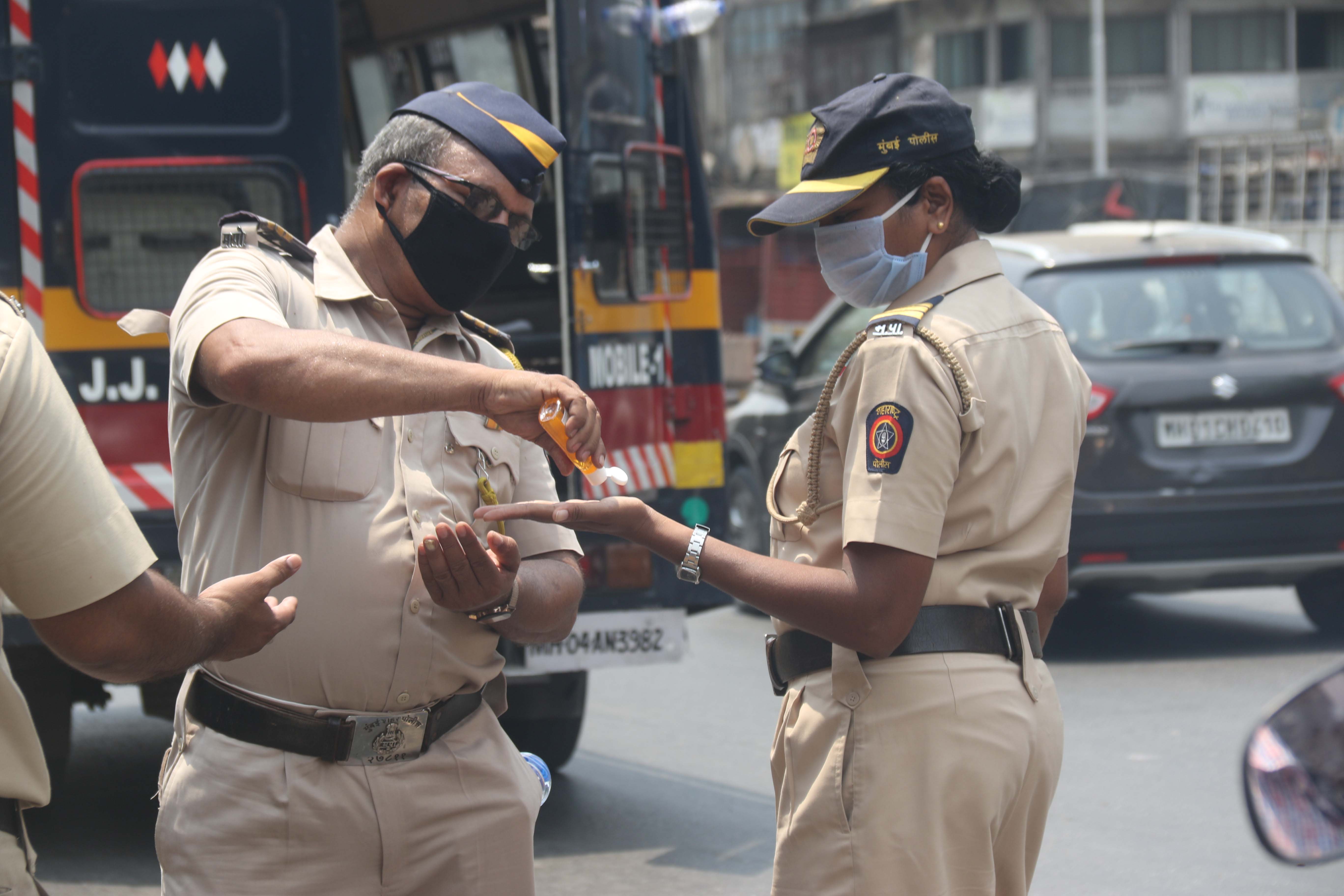 जेजे उड्डाणपूलावर नाकाबंदीदरम्यान सॅनिटायझरचा वापर करताना मुंबई पोलीस.