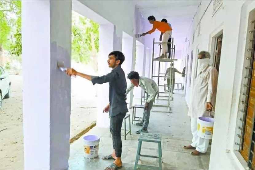 फुटपाथवर झाडाच्या सावलीखाली विसावलेला कामगार