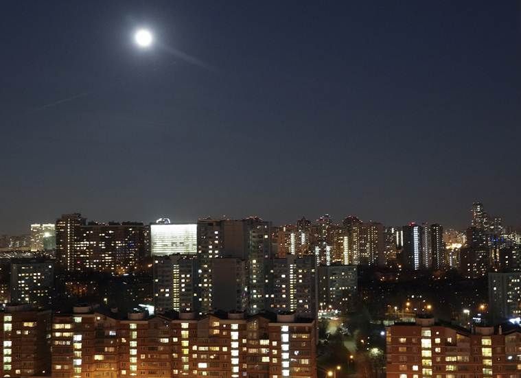 विजेच्या प्रकाशानं उजळून निघालेल्या मॉस्को शहरातील इमारती चंद्राच्या प्रकाशात न्हाऊन निघाल्या. (AP Photo/Dmitry Kozlov)