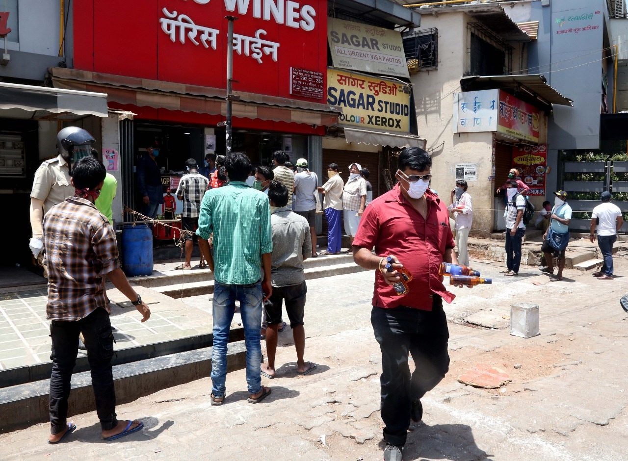 ....आणि खूप वेळ रांगेत उभं राहिल्यानंतर दारुची बाटली हातात मिळाली की चेहऱ्यावरचा आनंद काही औरच असतो. (छायाचित्र - अमित चक्रवर्ती)