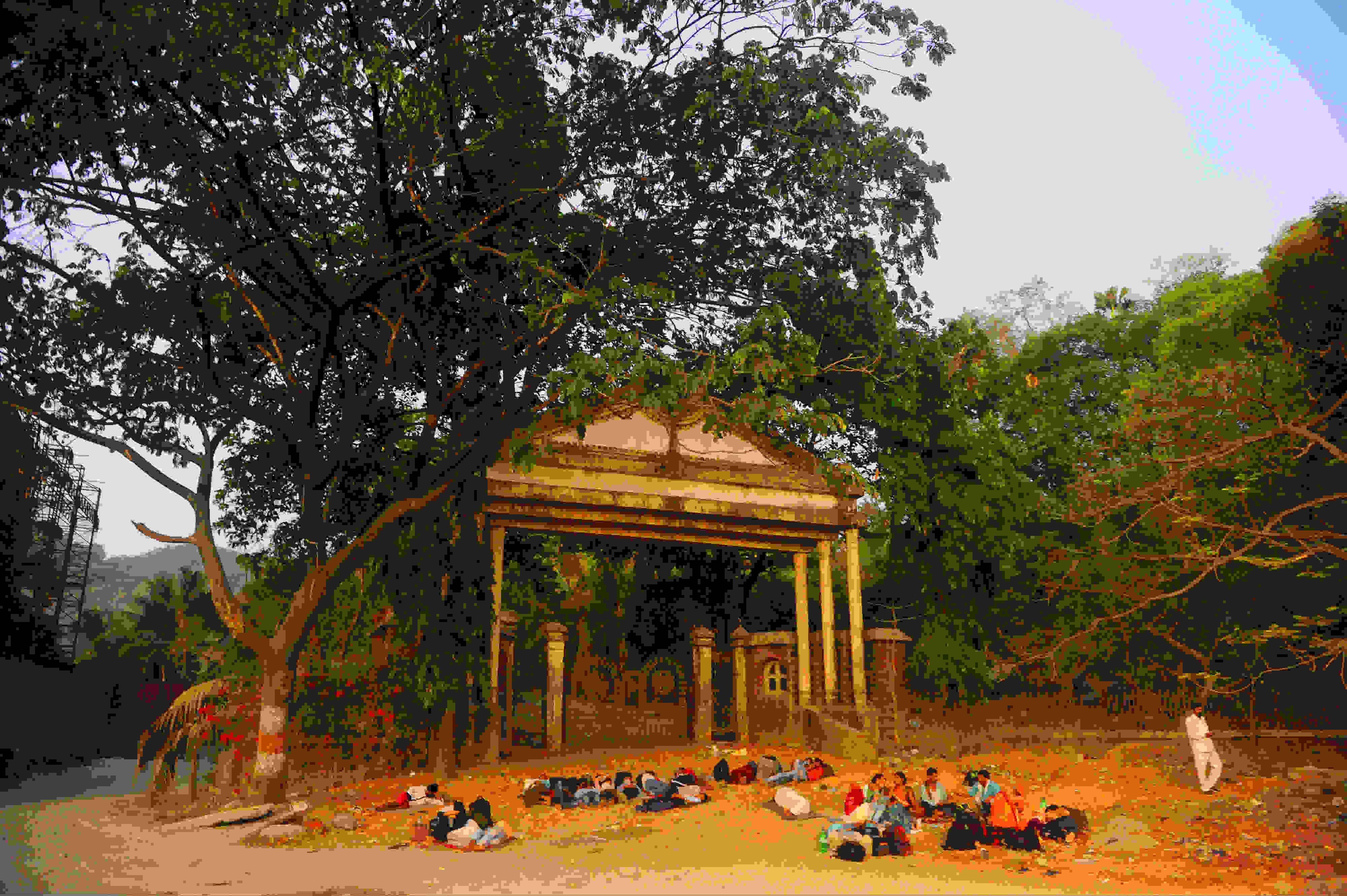 एका मोठ्या इमारतीसमोरील मोकळ्या जागेत तरुणांनी काही काळ विसावा घेतला.