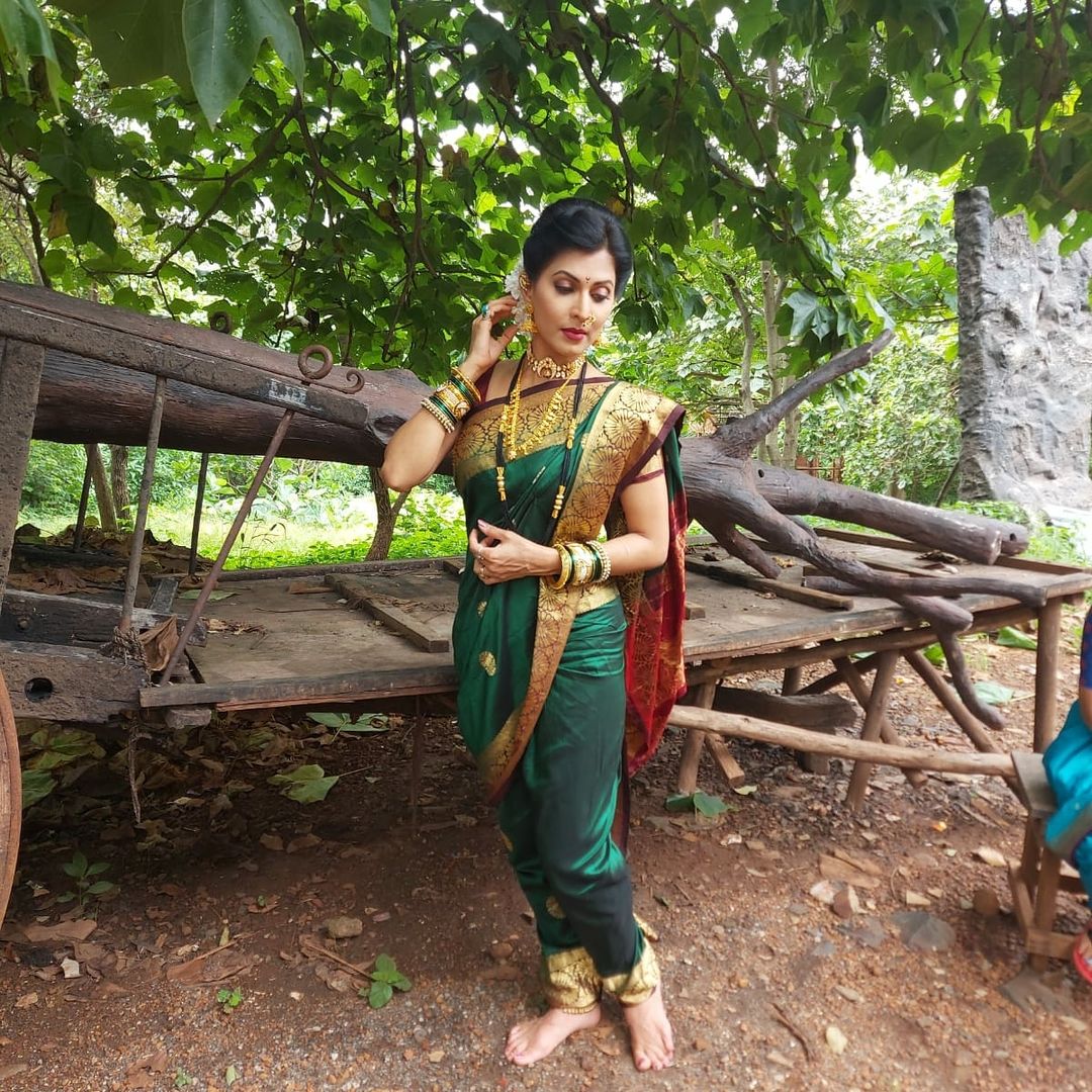 हिरव्या रंगाच्या साडीवर त्याला मॅचिंग अशी हेअरस्टाईल आणि दागिनेही तिने घातले आहेत.