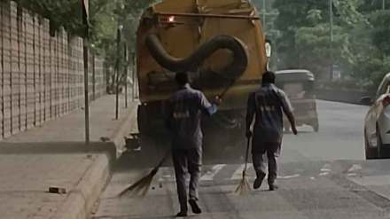 worker cleaning with a broom