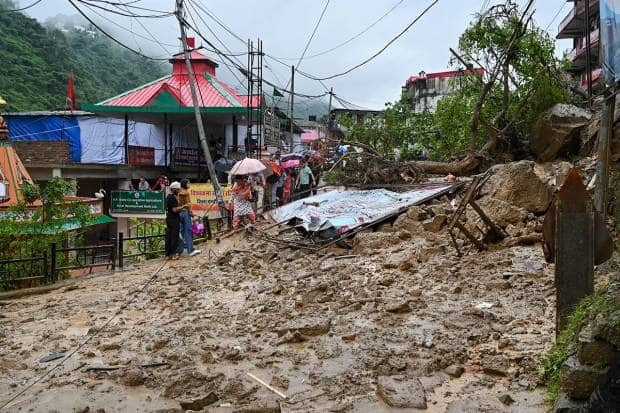 मंडीजवळ भूस्खलन झाल्यानंतर चंदीगड-मनाली महामार्ग बंद पडला. यावेळी प्रवाशांना मातीच्या ढिगाऱ्यावरून पायी चालत जावं लागलं. (पीटीआय फोटो)