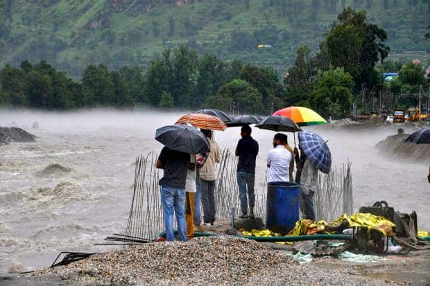 कुल्लूमध्ये मुसळधार पाऊस कोसळल्यानंतर बियास नदीच्या काठावर लोक उभे आहेत. (पीटीआय फोटो)