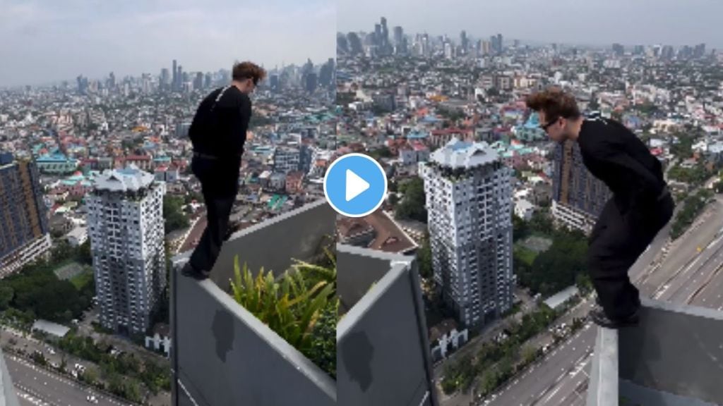 man standing on the railing of a tall building