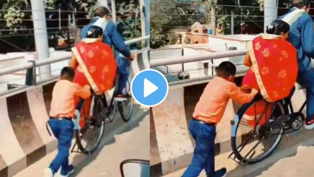 a boy shows love for parents by pushing bicycle