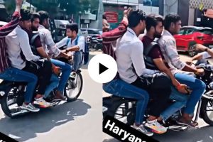 five young boys doing stunt on moving bike on a road