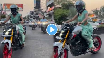 A young woman wearing a saree sits on a bike and cuts the youths