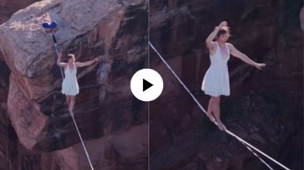 a woman walking on rope way on a high in a deep valley