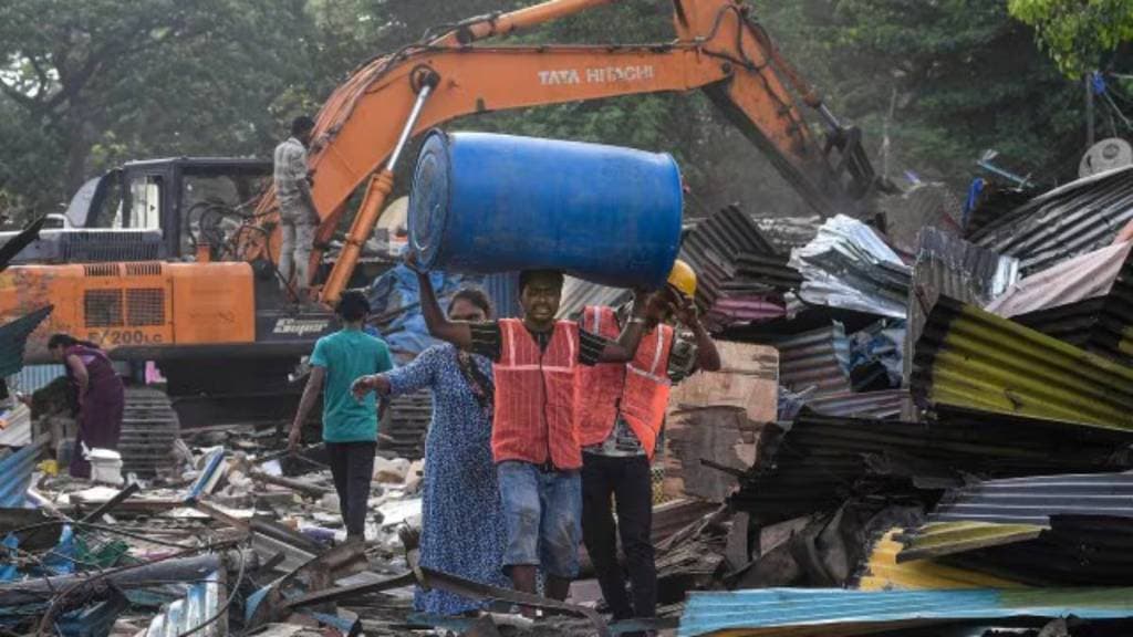 Workers shift belongings during an anti-encroachment drive at Jai Bhim Nagar slum colony, Powai, in Mumbai.
