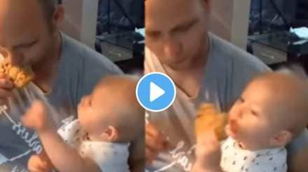 This baby quickly pulled the food from father's hand and eat