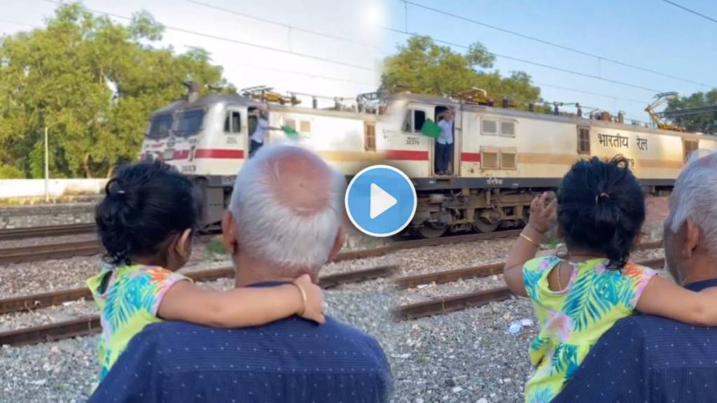 girl was making the gesture to say bye to the rail staff as he waved the green flag from the transport