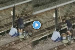 Video Shows Man standing near by railway track and preparing food with foot